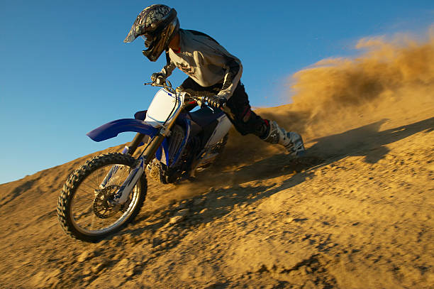 man motocross riding in desert terrain - motocross leisure activity sport motorcycle racing stock-fotos und bilder