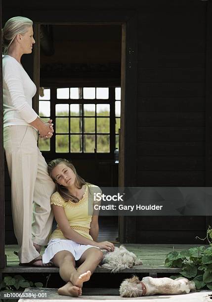 Mother And Daughter Relaxing On Porch Stockfoto und mehr Bilder von Faulheit - Faulheit, 12-13 Jahre, 45-49 Jahre