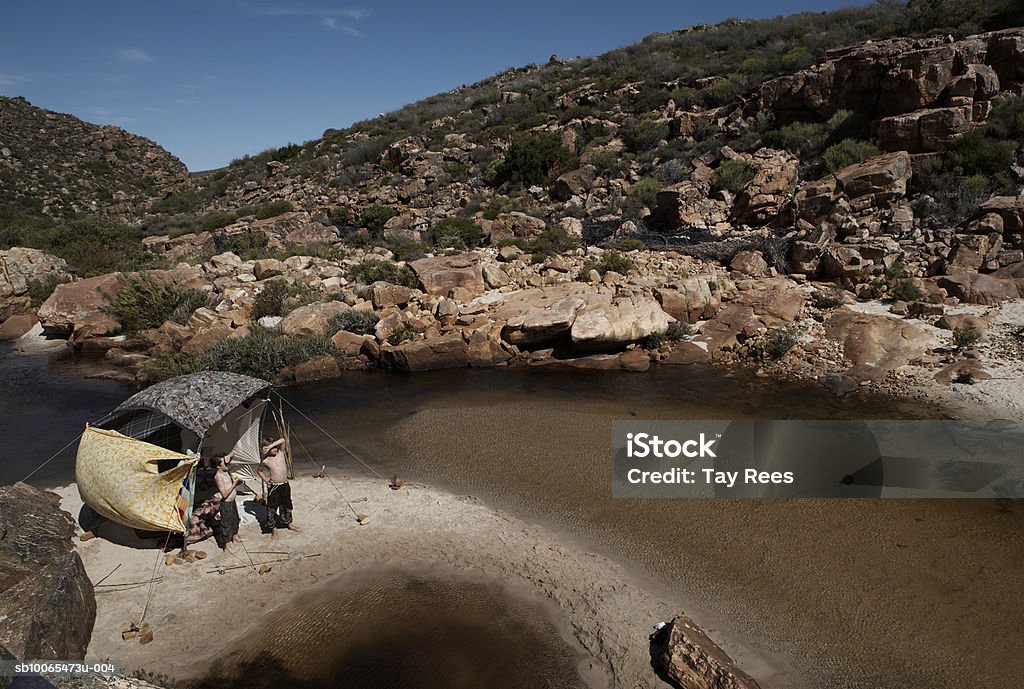 Two boys (10-13) standing beside tent by stream, elevated view  10-11 Years Stock Photo