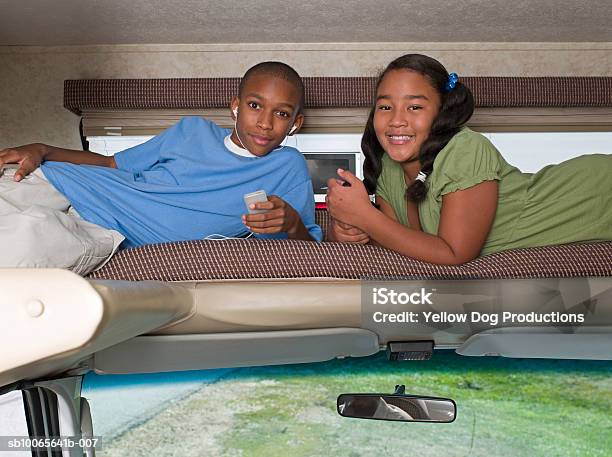 Children Sleeping Above Drivers Seat In Motorhome Boy Listening Mp3 Player - Fotografias de stock e mais imagens de 10-11 Anos