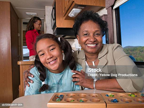 Grandmother With Children Mother Cooking In Background In Motorhome Foto de stock y más banco de imágenes de Africano-americano