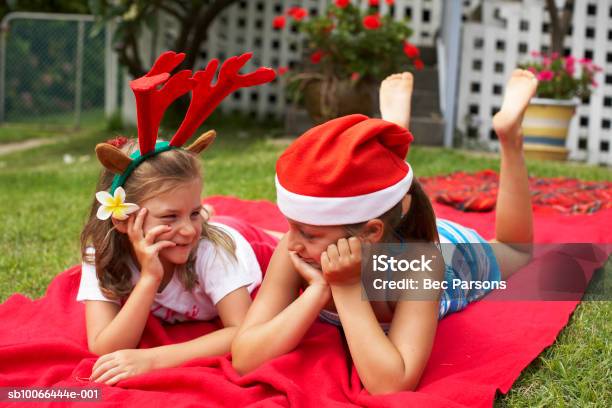 Niñas Usando Sombrero De Navidad Caer En Manta En Prado Foto de stock y más banco de imágenes de 6-7 años