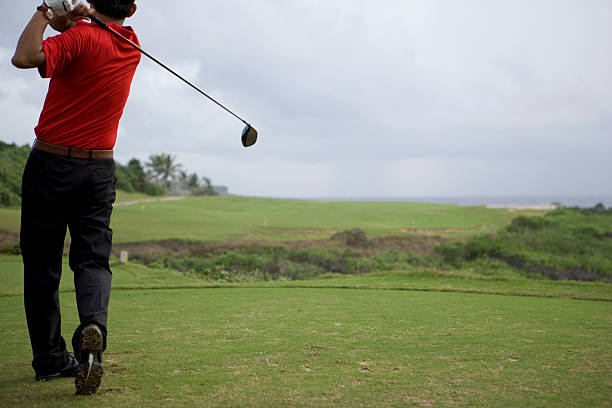 hombre balanceo de golf club, vista trasera - saipan fotografías e imágenes de stock