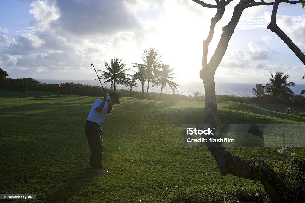 Man on golf course playing golf at dawn Saipan, USA Golf Stock Photo