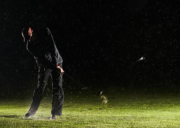 Man playing golf, hitting ball  night golf stock pictures, royalty-free photos & images