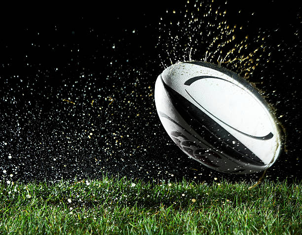 pelota de rugby en movimiento sobre hierba - rugby fotografías e imágenes de stock