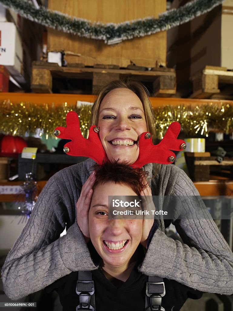 Young woman holding christmas reindeer antlers on other women's  head, portrait  20-24 Years Stock Photo