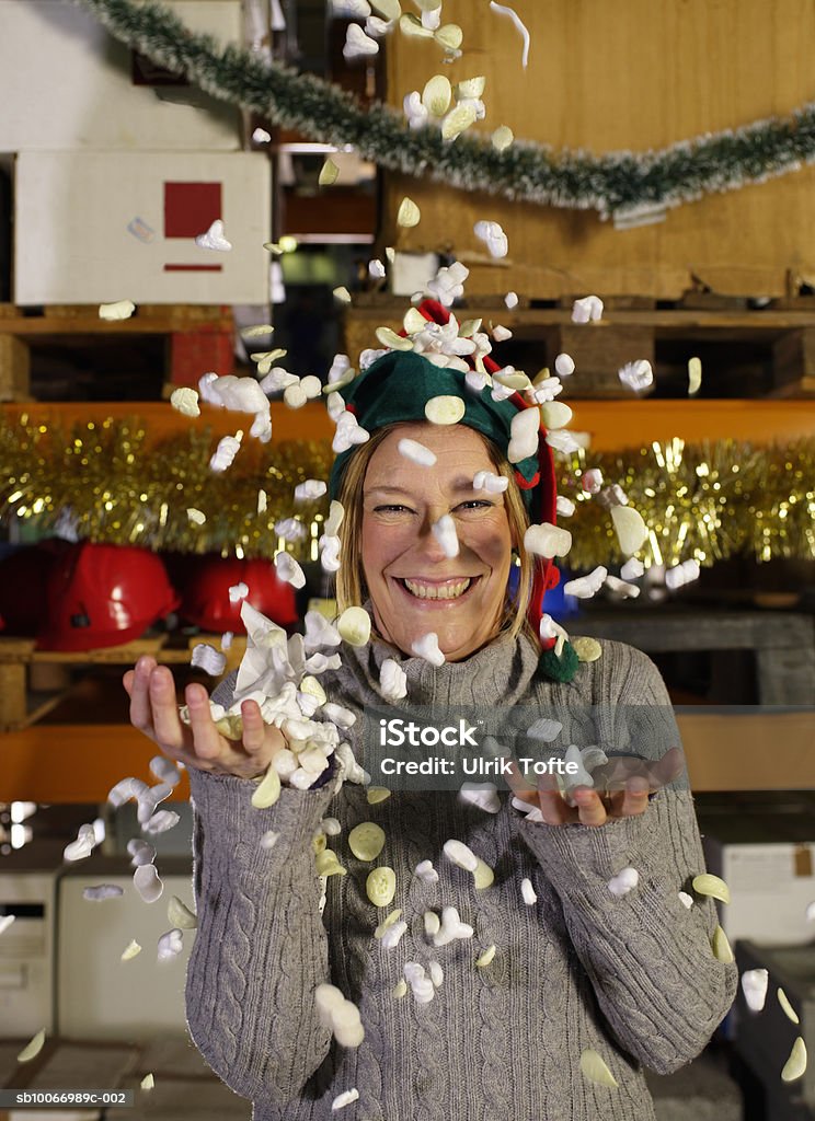 Woman throwing packing chips in air, portrait  35-39 Years Stock Photo