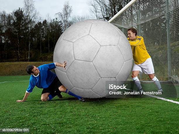 Two Football Players With Oversized Ball Stock Photo - Download Image Now - Soccer, Soccer Ball, Oversized Object