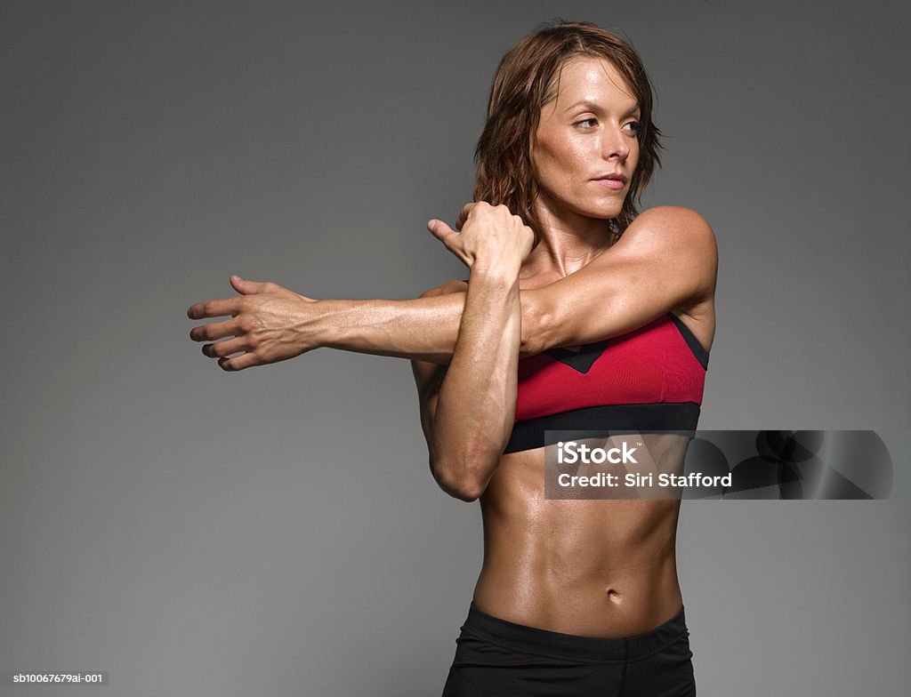 Atleta mujer estiramiento, foto de estudio - Foto de stock de Estirándose libre de derechos