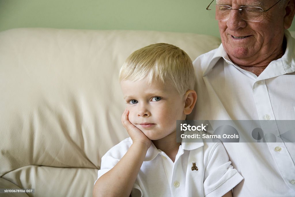Boy (4-5) with grandfather on sofa - Photo de Bébés garçons libre de droits