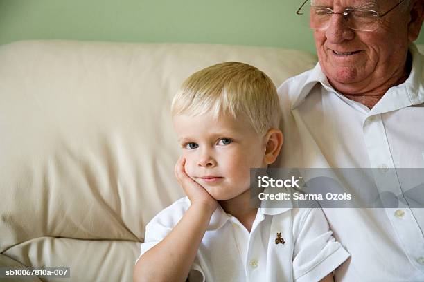 Photo libre de droit de Boy With Grandfather On Sofa banque d'images et plus d'images libres de droit de Bébés garçons - Bébés garçons, Cheveux blonds, Petits garçons