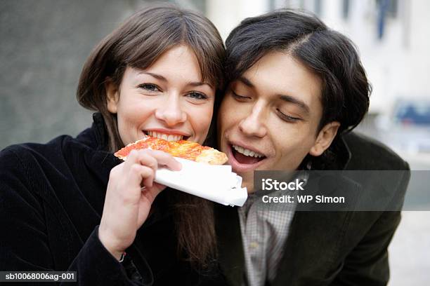 Couple Sharing Slice Of Pizza Outdoors Stockfoto en meer beelden van 20-24 jaar - 20-24 jaar, 30-34 jaar, Alleen volwassenen