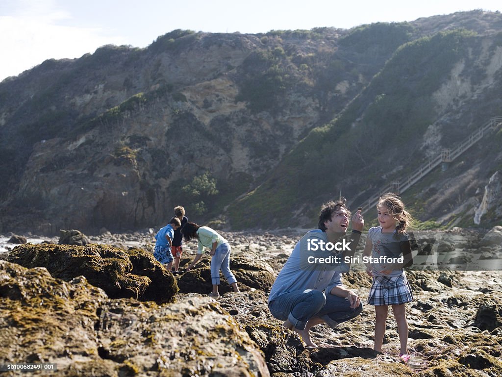 Família com Três crianças (6- 9) à procura de Conchas em seashor - Royalty-free Concha do mar Foto de stock