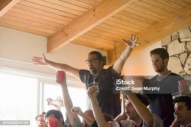 Group Of Friends Watching Tv Gesturing And Yelling Stock Photo - Download Image Now