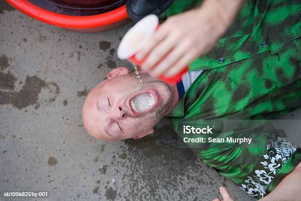Man Lying On Ground Having Beer Poured Into Mouth Stock Photo - Download Image Now - 35-39 Years, Adult, Adults Only