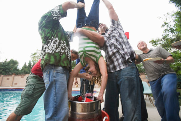 Group of men holding woman upside-down to do 'keg stand' USA, California, Los Angeles keg stock pictures, royalty-free photos & images