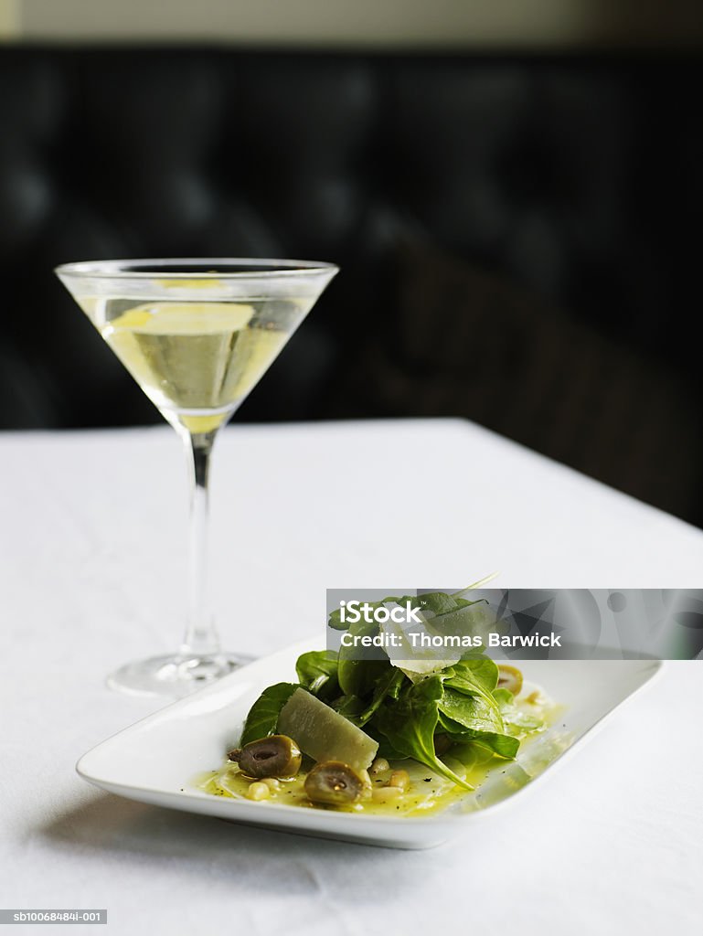 Turnip 'carpaccio' with arugula, parmesan, pine nuts and peaches, with vesper cocktail  Alcohol - Drink Stock Photo