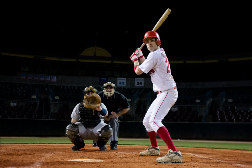 Baseball hit, sports and athlete on a outdoor field hitting a ball in a game with a baseball bat. Sport, baseball player and man busy with exercise, fitness and workout training on green grass