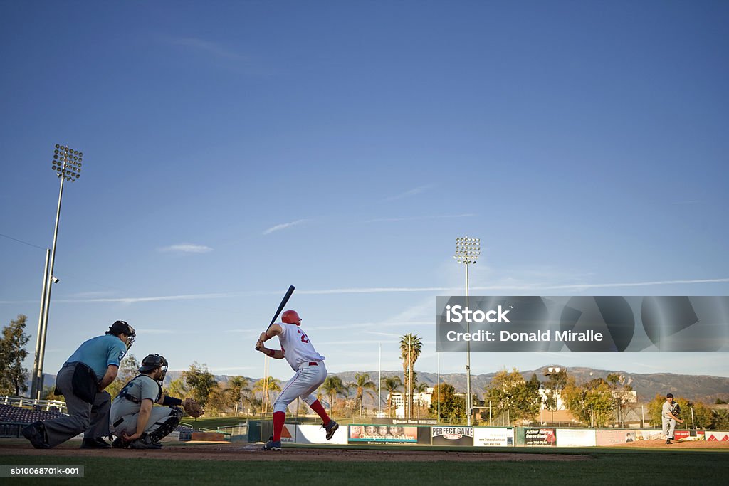 USA, California, San Bernardino, baseball players with batter swinging  Baseball - Sport Stock Photo