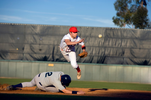 Baseball player, run and slide in dirt for game, contest or match on field, pitch or stadium. Man, baseball and dust in sand for sports to reach base fast for win, competition and sport in summer