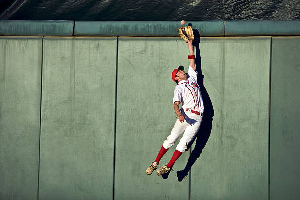 USA, California, San Bernardino, baseball player making leaping catch at wall  baseball player photos stock pictures, royalty-free photos & images