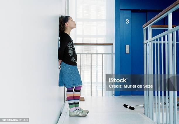 Girl Leaning On Wall In Corridor Side View Foto de stock y más banco de imágenes de 10-11 años