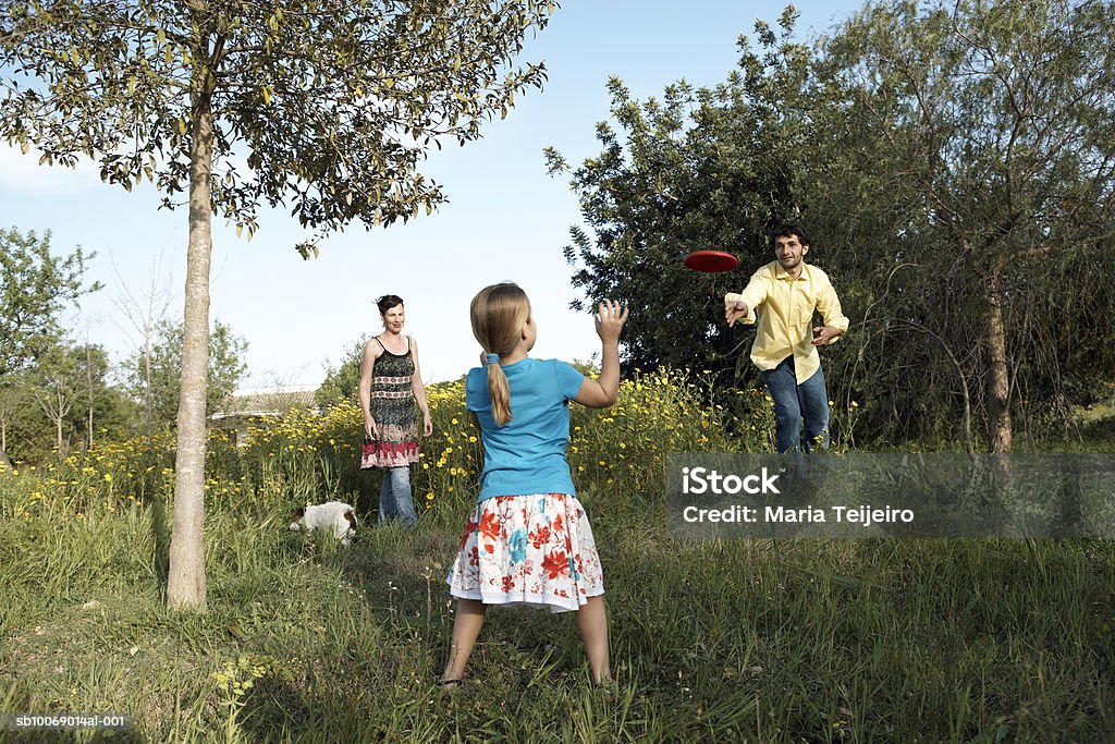 Mutter, Vater und Tochter (8.) mit frisbee Spielen im Garten - Lizenzfrei 35-39 Jahre Stock-Foto