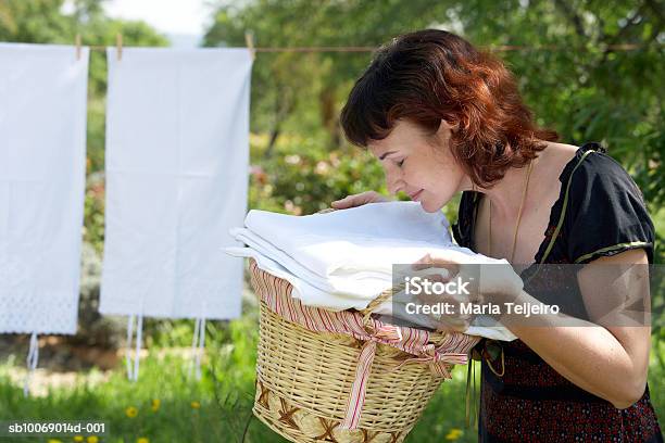 Mujer De Mediana Edad Oliendo Fleshly Lavar La Ropa En El Jardín Foto de stock y más banco de imágenes de Oler