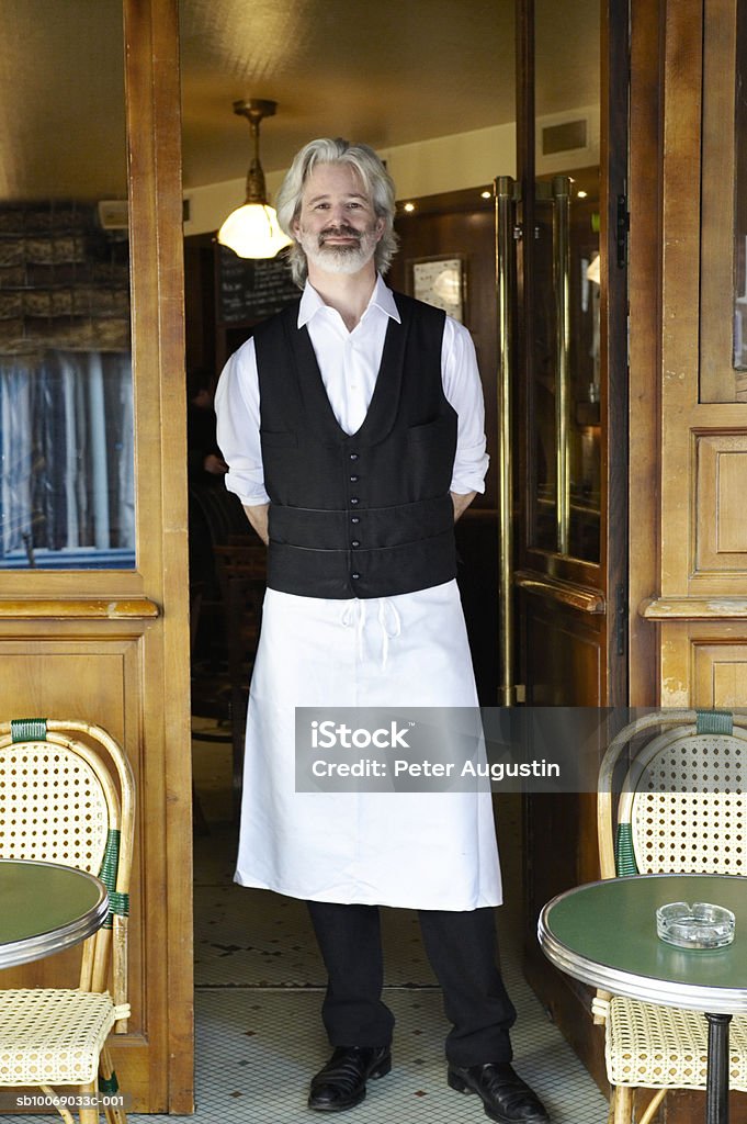 France, Paris, portrait of waiter standing in cafe door  Waiter Stock Photo