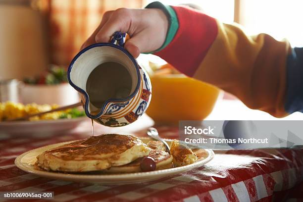 Teenage Boy Pouring Syrup On Pancakes Stock Photo - Download Image Now - 14-15 Years, Bowl, Breakfast