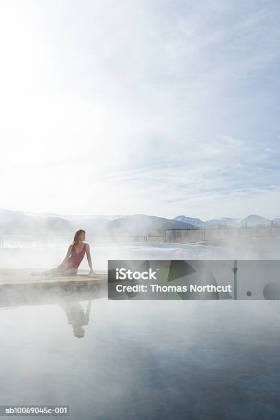 Junge Frau Sitzt Am Pool Stockfoto und mehr Bilder von Thermalquelle - Thermalquelle, Winter, Schwimmbecken