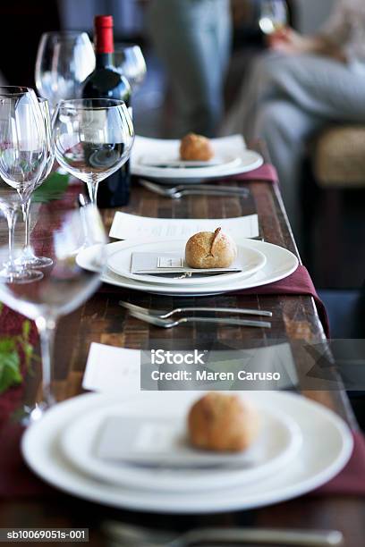 Dinner Setting On Table People In Background Stock Photo - Download Image Now - Anticipation, Bottle, Bun - Bread