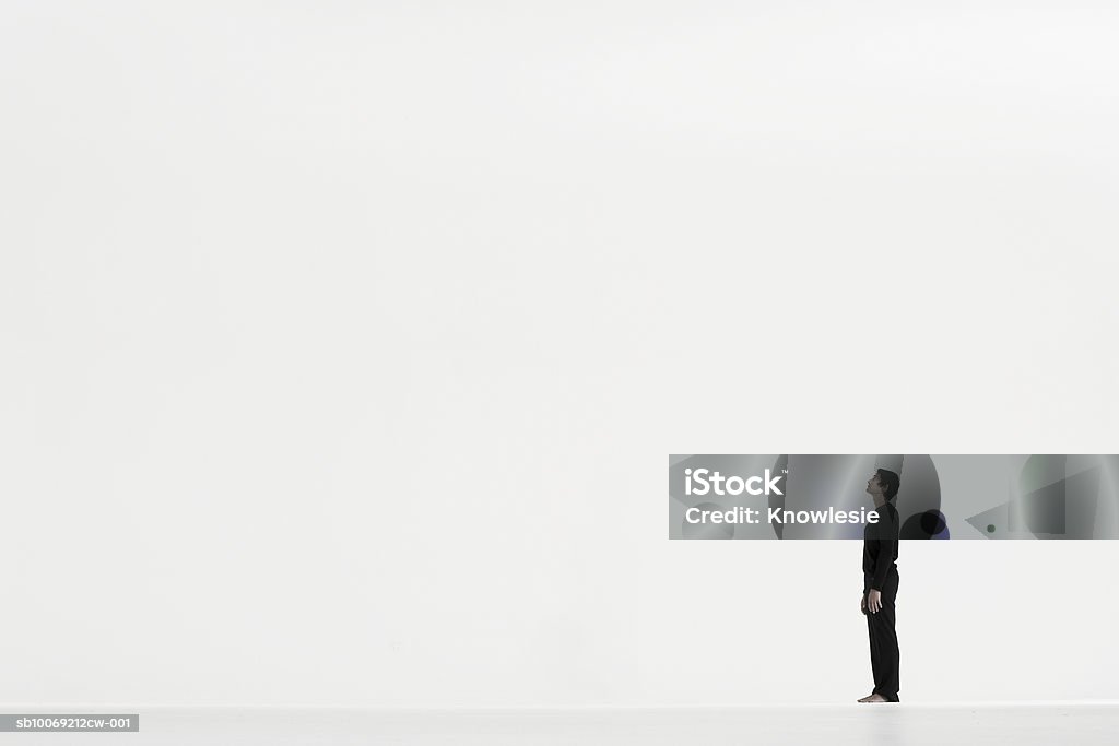 Homme debout dans la distance sur fond blanc, vue de côté - Photo de Regarder en l'air libre de droits