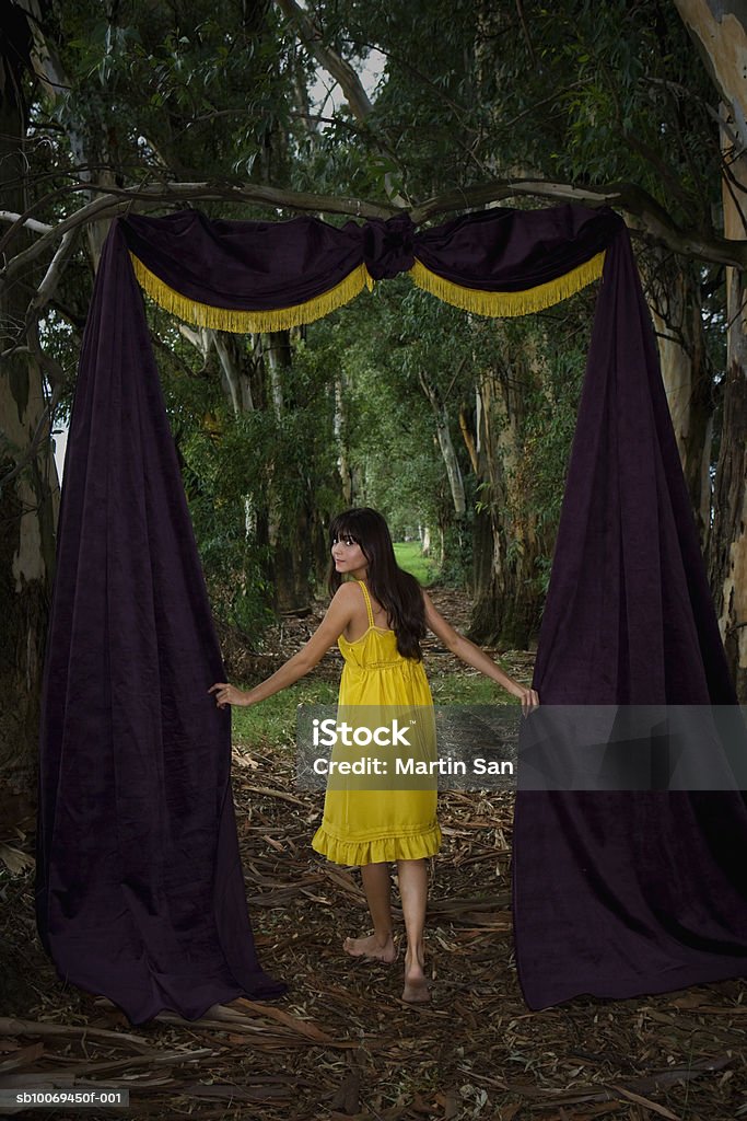 Young woman in forest with door made up of curtain  Doorway Stock Photo