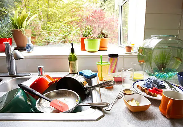 Photo of Dirty dishes piled in kitchen sink, close-up