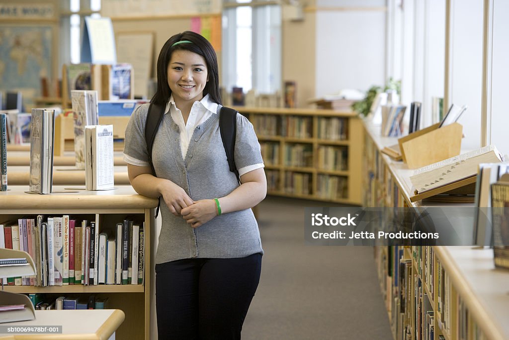 School girl (14-15) by bookshelf in library, portrait USA, Washington State, Bellevue, Interlake High School 14-15 Years Stock Photo