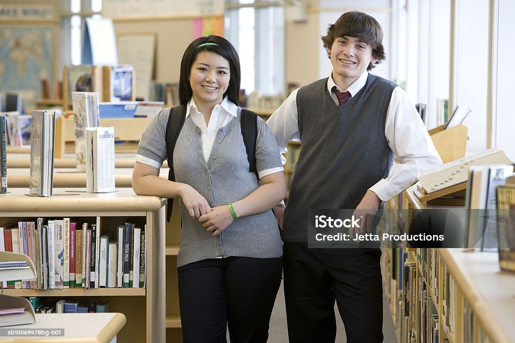 School children (15-17) by bookshelves in library, portrait USA, Washington State, Bellevue, Interlake High School Teenage Boys Stock Photo
