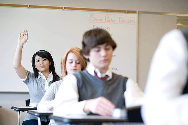 Pupils (15-18) in school classroom, differential focus USA, Washington State, Bellevue, Interlake High School teenage high school girl raising hand during class stock pictures, royalty-free photos & images