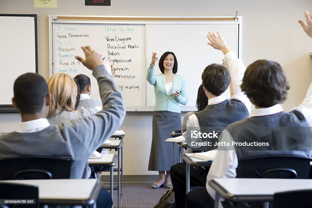 School children (14-18) raising hands in class USA, Washington State, Bellevue, Interlake High School Teacher Stock Photo