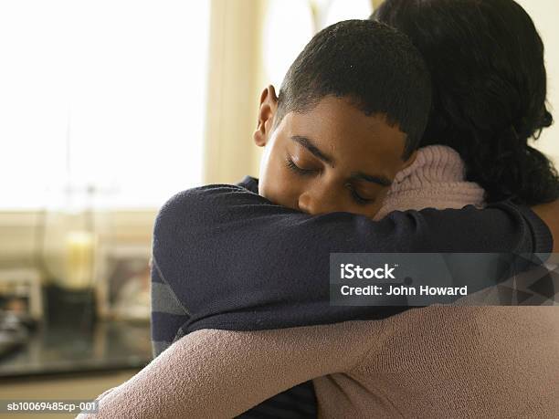 Boy Hugging Mother At Home Stock Photo - Download Image Now - Embracing, Child, Mother