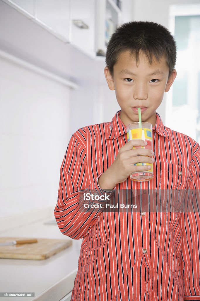 Boy (10-11) drinking in kitchen, portrait - Foto de stock de 10-11 años libre de derechos