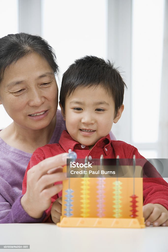 Boy (4-5) and grandmother playing with abacus  4-5 Years Stock Photo