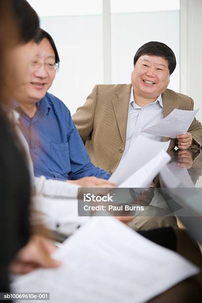 Businesspeople Reading Documents In Conference Room Smiling Stockfoto und mehr Bilder von Geschäftsfrau