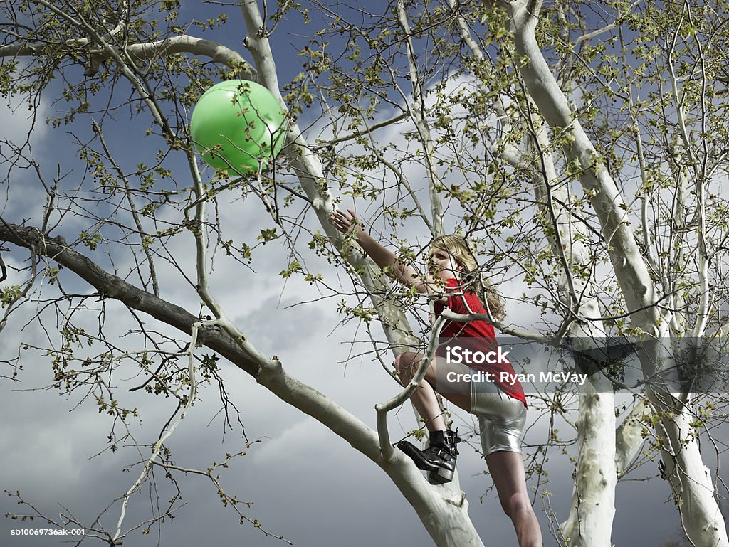 Jeunes filles (14-15) Escalade arbre pour ballon - Photo de Atteindre libre de droits