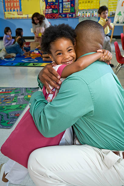 girl (4-5) embracing father in classroom - family cheerful family with one child texas photos et images de collection