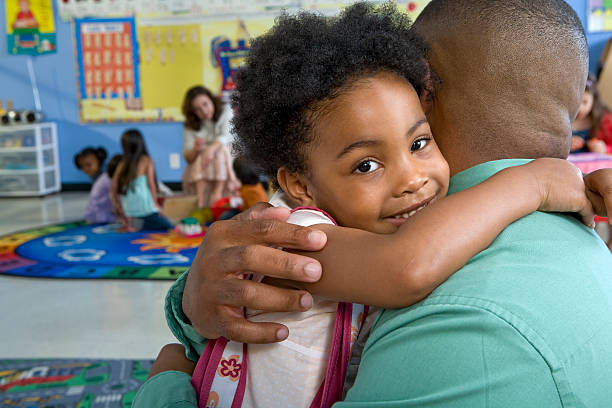 girl (4-5) embracing father in classroom - family cheerful family with one child texas imagens e fotografias de stock