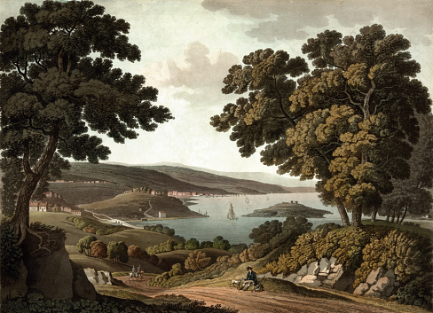 Vintage landscape image features an early view of Washington, D.C. made from the approximate site of present-day Wisconsin Avenue and R Street, NW. It shows a cart on a road overlooking the Potomac River, Georgetown, the bridge over Rock Creek and Analostan (now Roosevelt) Island, along with the buildings of the new Federal City in the distance.
