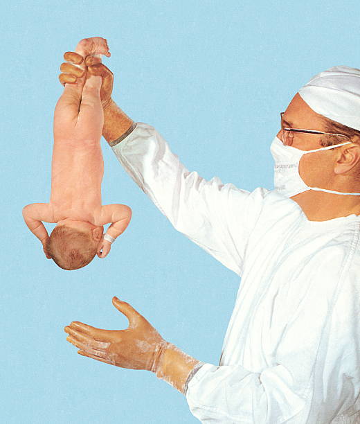 stockillustraties, clipart, cartoons en iconen met doctor holding new born baby upside down - beschermend masker werkkleding