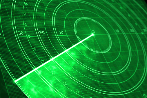 Detail of a green military radar screen with glowing coordinates and positioning numbers. Scanner axis is visible while spinning around the center. Field is empty and no objects are detected. Diminishing perspective and selective focus.